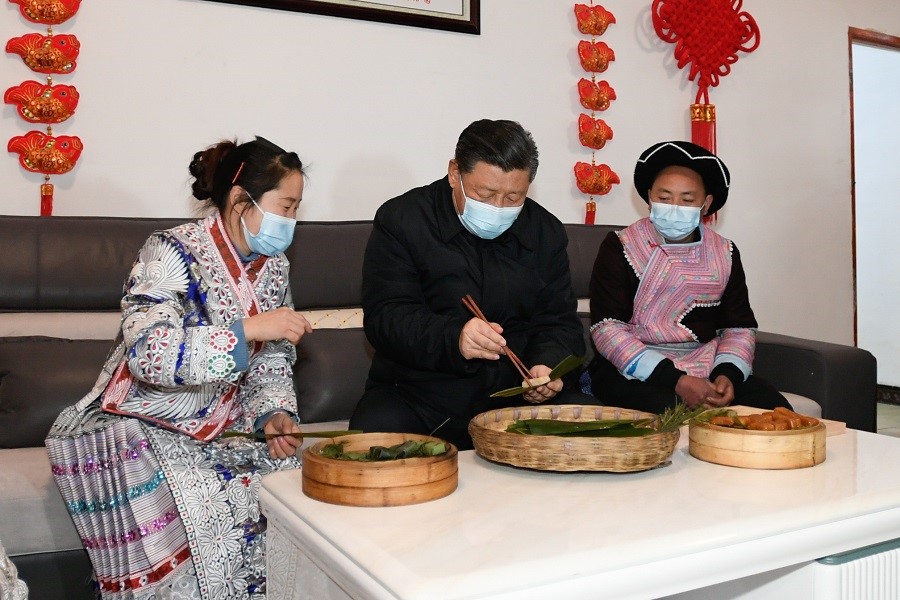 2021年2月3日下午，習(xí)近平在貴州畢節(jié)市黔西縣新仁苗族鄉(xiāng)化屋村苗族村民趙玉學(xué)家，同一家人邊聊家常邊制作當(dāng)?shù)貍鹘y(tǒng)節(jié)日食品黃粑。新華社記者 李學(xué)仁 攝